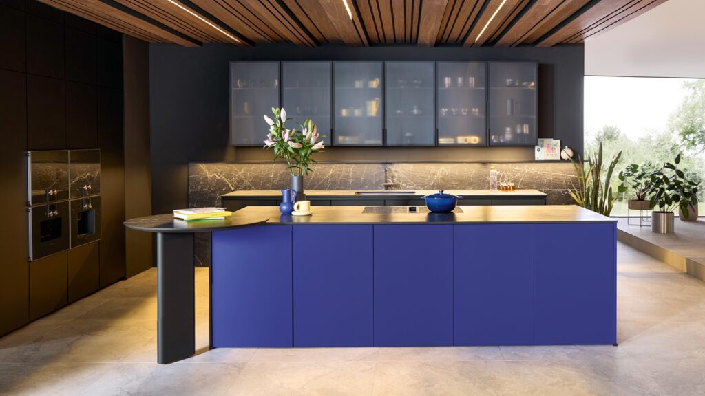 Ultramarine kitchen with round breakfast table and fluted glass wall units 