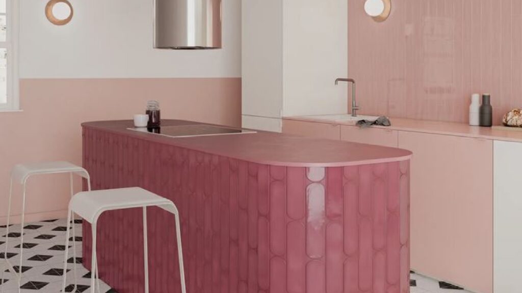 Kitchen with raspberry tiled island with two white stools and pink tiled wall