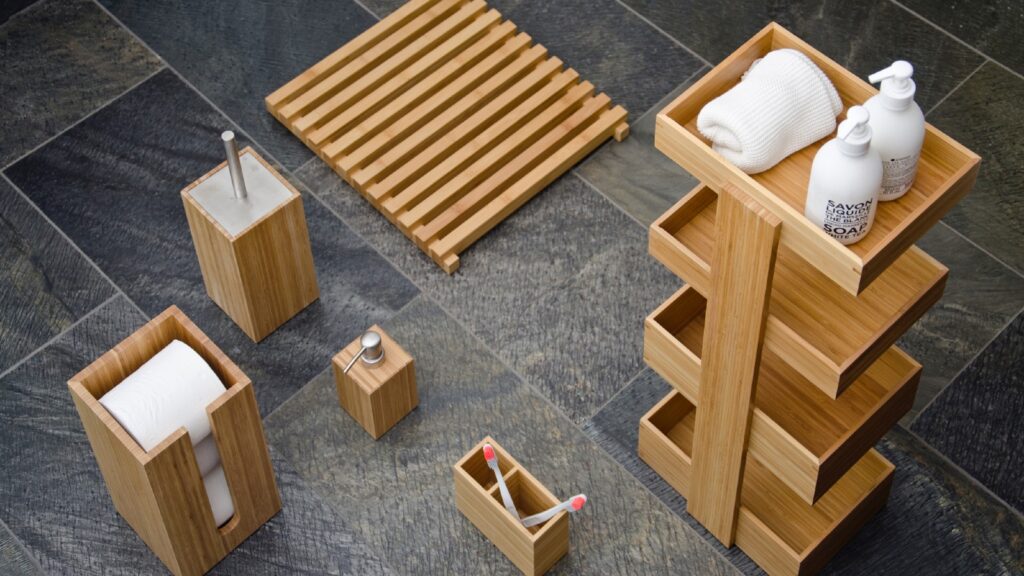 A collection of bamboo bathroom accessories on a tiled floor